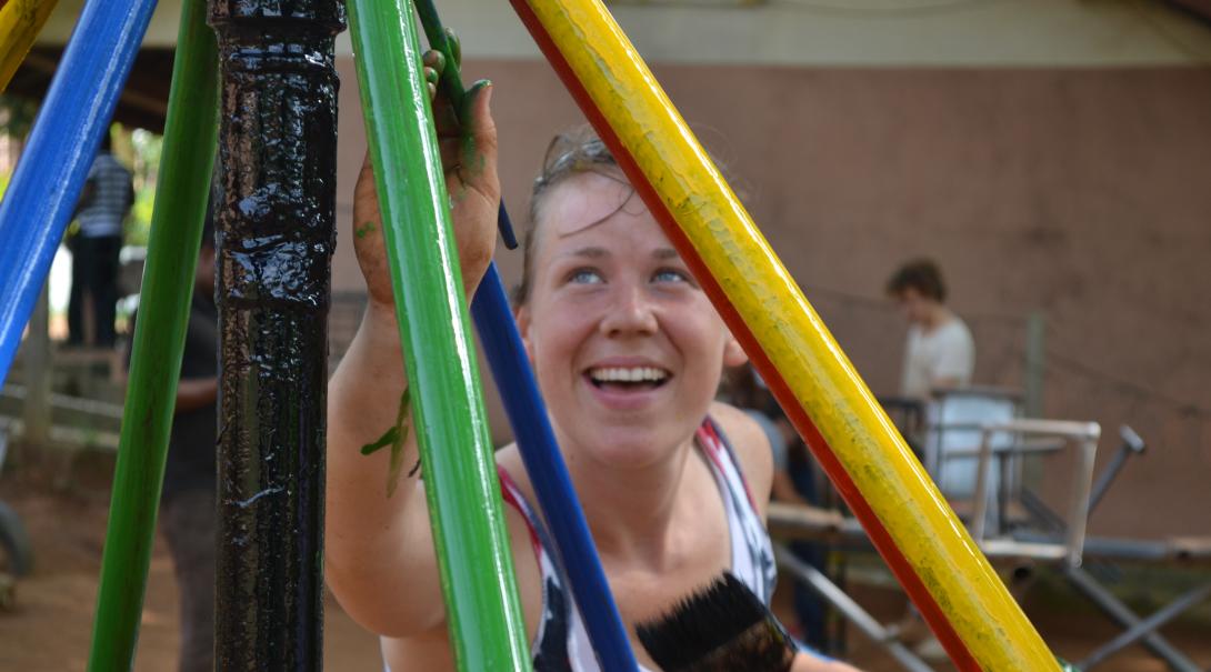 A Projects Abroad volunteer building in Ghana, helps paint a playground A volunteer paints a playground as part of her construction volunteering in Ghana